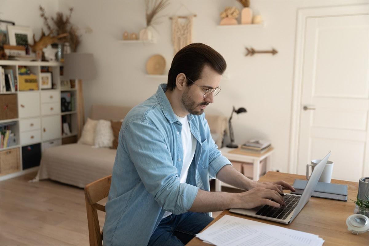 Man on computer working full-time, fully remote from home