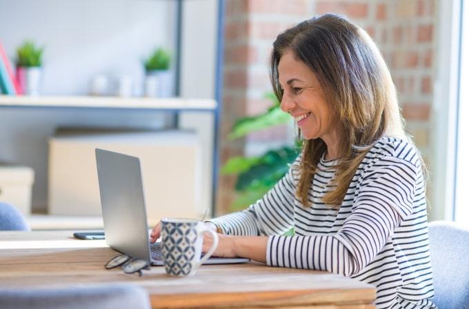 Woman on computer working full-time, fully remote from home
